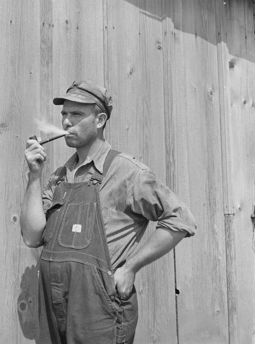 Barns, farmer, tobacco pipe, smoking, Farms, Portraits - Individual, Iowa History, Iowa, Library of Congress, overalls, wooden building, history of Iowa, Labor and Occupations