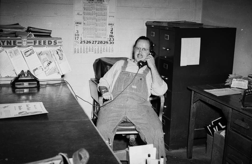 Portraits - Individual, overalls, United States, history, ia, glasses, Photos, Labor and Occupations, mustache, Coon Rapids Enterprise, office chair, telephone, Iowa, historic, IA, Coon Rapids, filing cabinet
