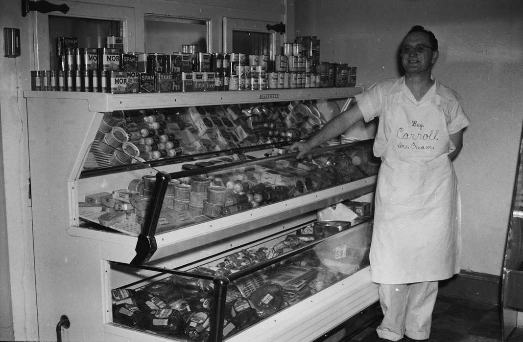 Businesses and Factories, Food and Meals, employee, history, canned food, deli meat, glasses, Labor and Occupations, cooler, Photos, apron, Iowa, IA, Portraits - Individual, United States, ia, Coon Rapids Enterprise, historic, smile, Coon Rapids
