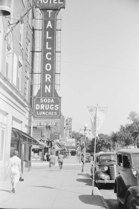 history of Iowa, sidewalk, banner, automobile, lamppost, pedestrian, Businesses and Factories, Cities and Towns, awning, Iowa, Library of Congress, street light, Motorized Vehicles, car, intersection, Main Streets & Town Squares, Iowa History