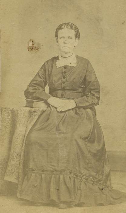carte de visite, dropped shoulder seams, table, woman, Olsson, Ann and Jons, Iowa History, bishop sleeves, Portraits - Individual, Iowa, tablecloth, dress, IA, hoop skirt, history of Iowa, necklace, book