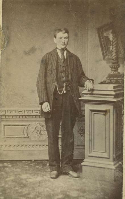 man, Olsson, Ann and Jons, painted backdrop, carte de visite, Iowa History, watch chain, sack coat, vest, patterned carpet, Portraits - Individual, Marshalltown, IA, Iowa, four in hand tie, history of Iowa