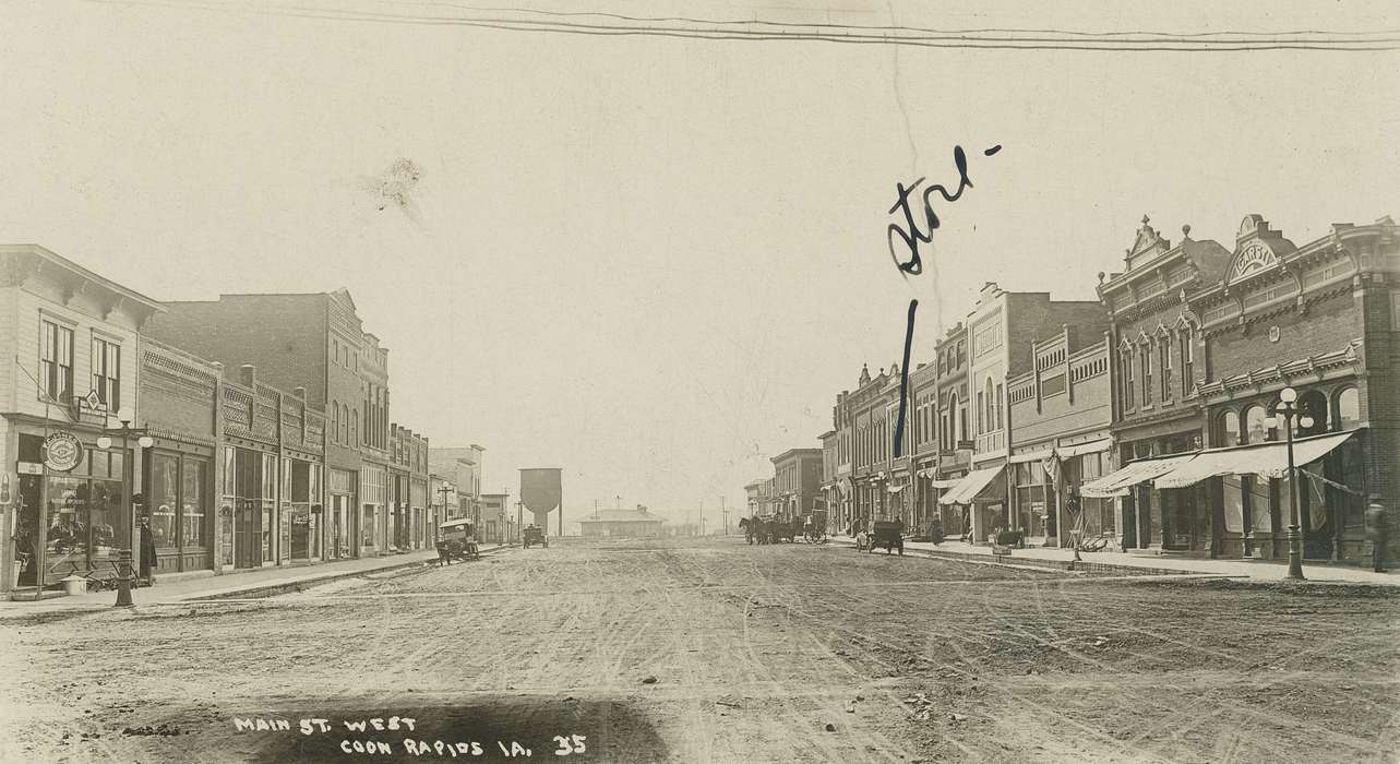 Motorized Vehicles, horse, Animals, street lamp, sign, Businesses and Factories, Cities and Towns, Coon Rapids Enterprise, Children, dirt road, Portraits - Group, Main Streets & Town Squares, Labor and Occupations, awning, brick building