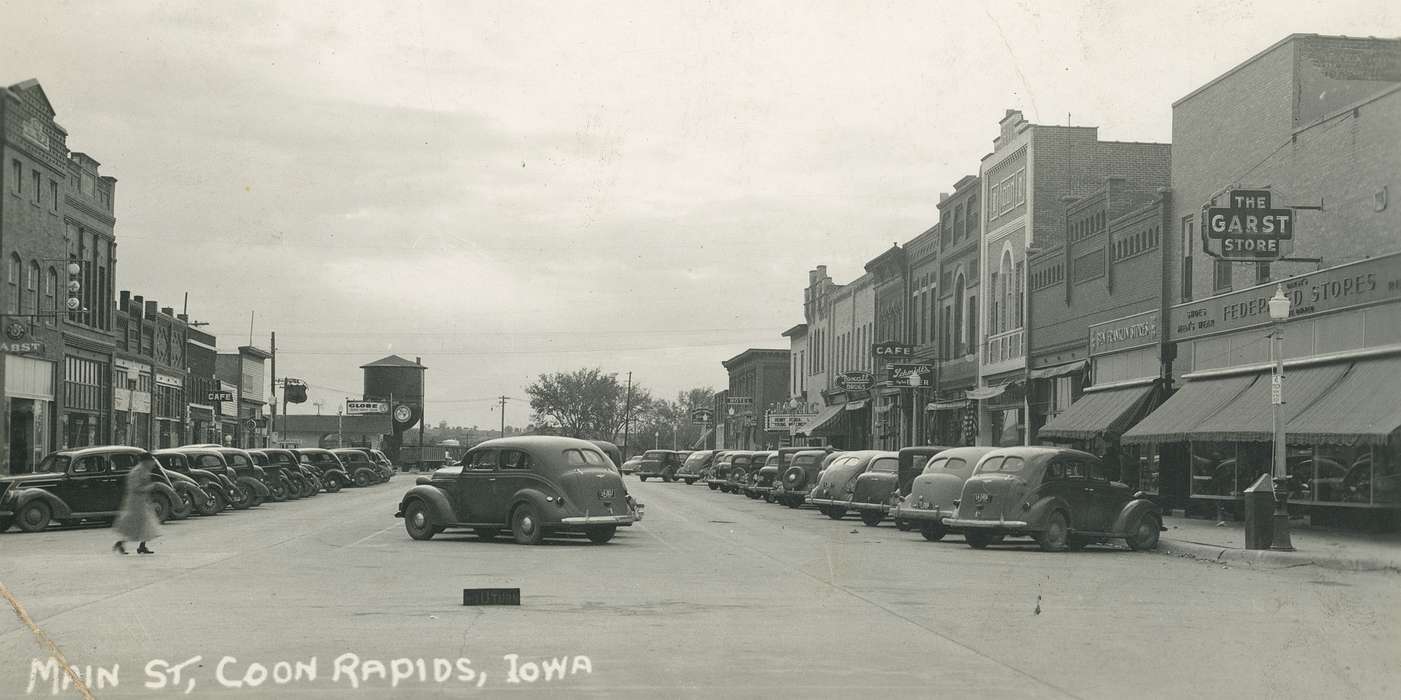 Portraits - Individual, paved road, Motorized Vehicles, correct date needed, Businesses and Factories, Cities and Towns, Coon Rapids Enterprise, Main Streets & Town Squares, car, awning, brick building