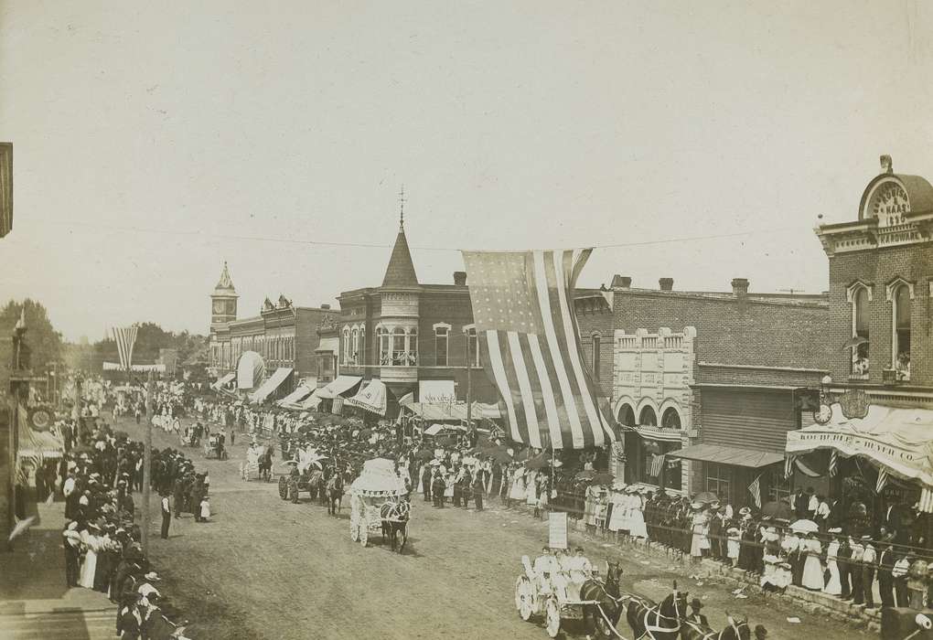 horse carriage, Main Streets & Town Squares, brick building, parade, Entertainment, Iowa History, clock tower, Cities and Towns, Iowa, Waverly Public Library, crowd, history of Iowa, electrical pole, dirt street, clock, correct date needed, horse, american flag, Animals, Businesses and Factories, awning