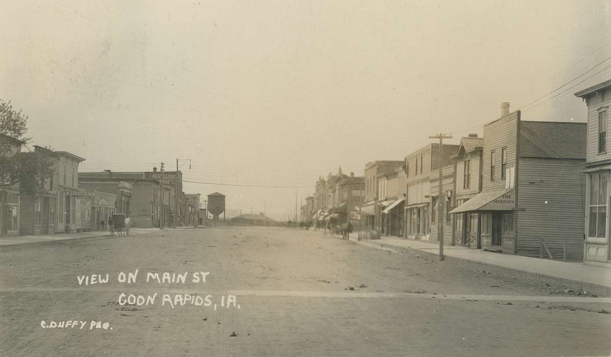 buggy, horse, Animals, power line, Businesses and Factories, Cities and Towns, Coon Rapids Enterprise, dirt road, Portraits - Group, Main Streets & Town Squares, awning, brick building