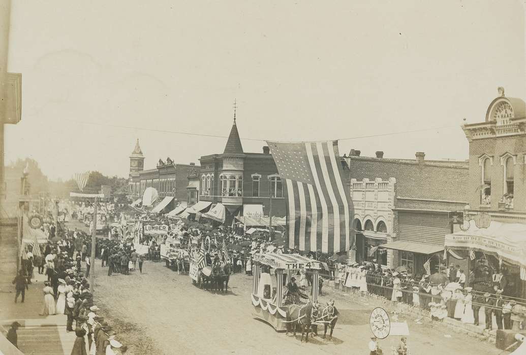 Waverly Public Library, umbrella, parade float, Iowa, Iowa History, Entertainment, Aerial Shots, brick building, carriage, american flag, Main Streets & Town Squares, history of Iowa, dirt street, Animals, clock, Cities and Towns, Businesses and Factories, electrical pole, horse, parade, clock tower, correct date needed, awning, crowd