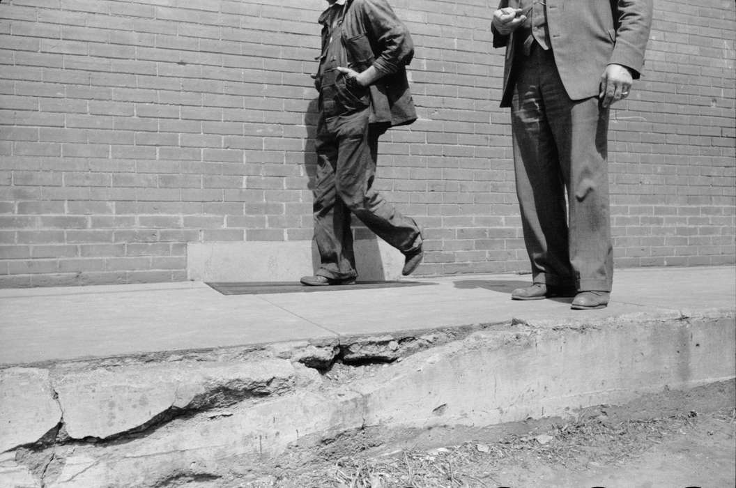 sidewalk, Library of Congress, history of Iowa, Cities and Towns, Iowa, Iowa History, Portraits - Group, work clothes, broken sidewalk, brick building, men, suit