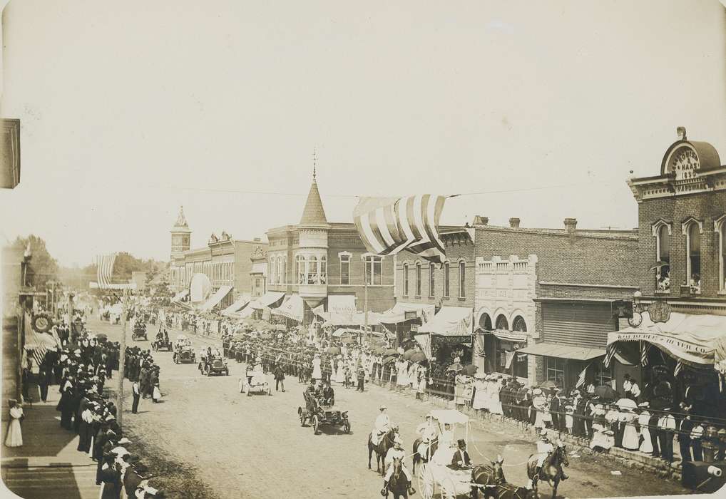 parade, dirt street, Entertainment, automobile, correct date needed, Cities and Towns, carriage, history of Iowa, Motorized Vehicles, american flag, Businesses and Factories, crowd, Iowa History, car, umbrella, brick building, Iowa, Waverly Public Library, Main Streets & Town Squares, Aerial Shots, horse, clock tower, Animals, clock, bank