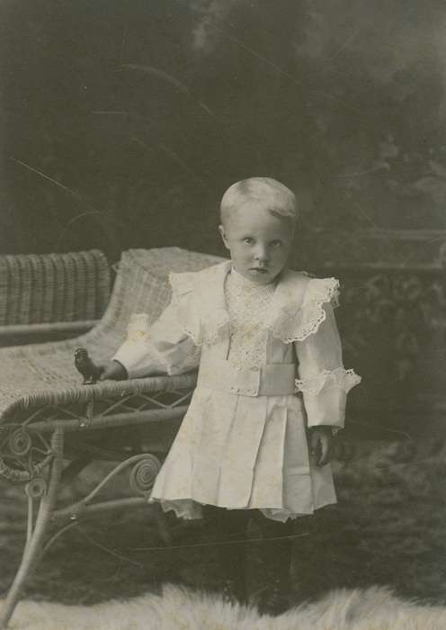 wicker chair, toy, lace collar, little lord fauntleroy suit, pleats, child, painted backdrop, Reinbeck, IA, Olsson, Ann and Jons, Children, Iowa History, cabinet photo, Portraits - Individual, Iowa, boy, history of Iowa