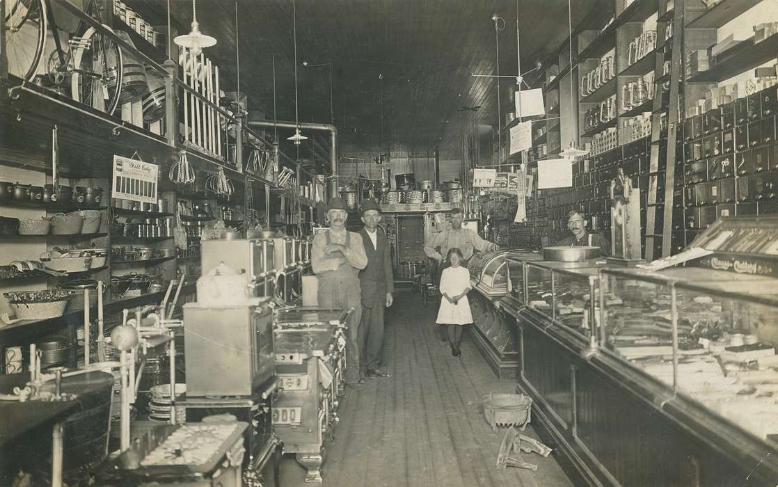 hardware store, bicycle, suspenders, clock, barrel, bowler hat, display case, Portraits - Group, light, moustache, building interior, history of Iowa, Labor and Occupations, Businesses and Factories, correct date needed, girl, lamp, overalls, Waverly Public Library, man, Iowa History, stove, Iowa, suit, Children