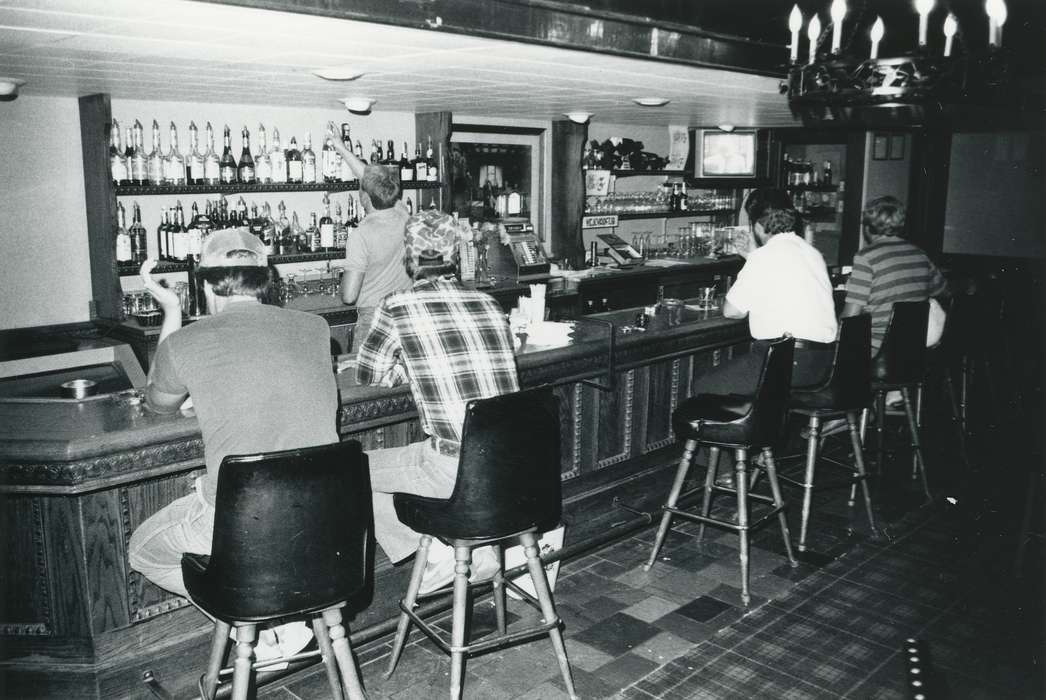 cash register, bar, plaid shirt, baseball cap, barstool, shelf, Iowa History, history of Iowa, bottle, Waverly Public Library, counter, building interior, alcohol, Iowa, Labor and Occupations, Businesses and Factories