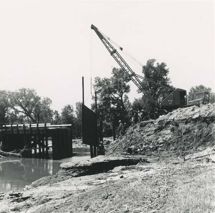 construction materials, crane, river, flood aftermath, Iowa History, construction, tree, Labor and Occupations, people, Floods, bridge, Iowa, Waverly Public Library, history of Iowa, Lakes, Rivers, and Streams, Motorized Vehicles, Waverly, IA, construction crew, hard hat, cedar river, summer