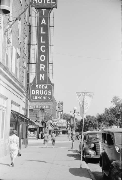 cars, Cities and Towns, pedestrian, Portraits - Group, Leisure, history of Iowa, Main Streets & Town Squares, brick building, hotel sign, sidewalk, storefront awning, Businesses and Factories, intersection, hotel, lamppost, Iowa History, Iowa, Motorized Vehicles, Library of Congress