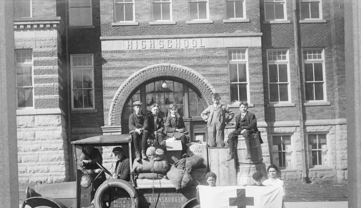 Library of Congress, Cities and Towns, Iowa History, Schools and Education, Children, man, truck, high school, Iowa, tire, brick building, bag, history of Iowa, boy, Motorized Vehicles, Portraits - Group, Civic Engagement, red cross