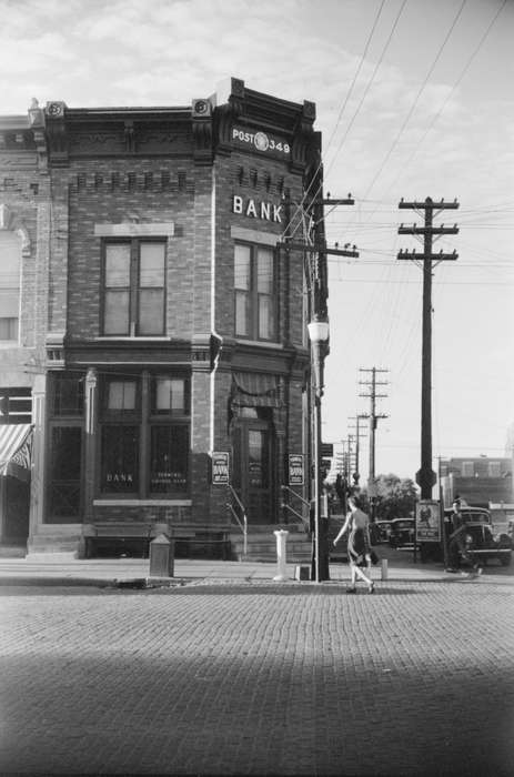 electrical pole, history of Iowa, sidewalk, lamppost, american legion post, Businesses and Factories, Cities and Towns, bank, power lines, Iowa, Iowa History, brick building, Library of Congress, Motorized Vehicles, street corner, cars, Main Streets & Town Squares, cobblestone street