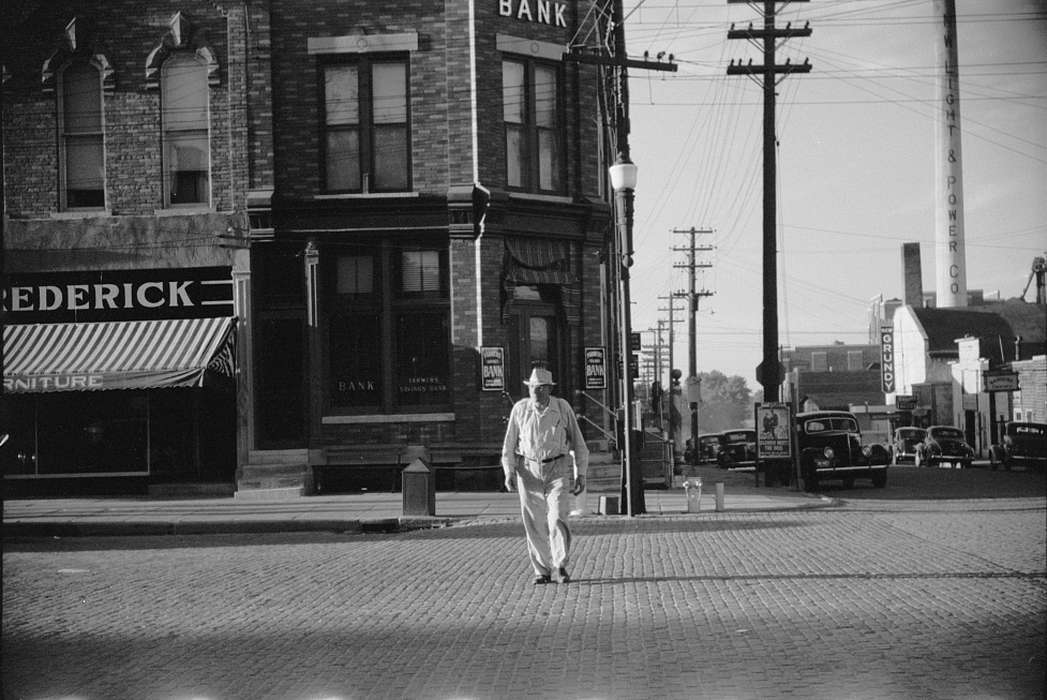 street corner, electric company, cobblestone street, Library of Congress, bank, Iowa, Main Streets & Town Squares, Cities and Towns, lamppost, electrical pole, history of Iowa, Iowa History, Businesses and Factories, sidewalk, Motorized Vehicles, brick building, power lines, cars, Portraits - Individual