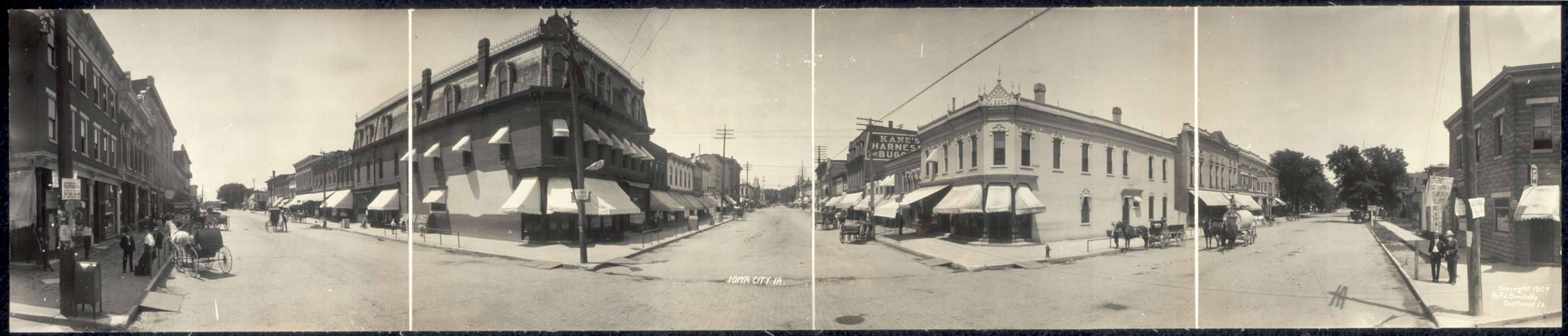 history of Iowa, brick building, Businesses and Factories, Library of Congress, Main Streets & Town Squares, storefront awning, power lines, man, kids, Families, sidewalk, horse and cart, woman, Leisure, Labor and Occupations, Cities and Towns, horse, Portraits - Group, Iowa History, pedestrian, Iowa, Animals, cobblestone street, panorama, horse and buggy, Children, electrical pole