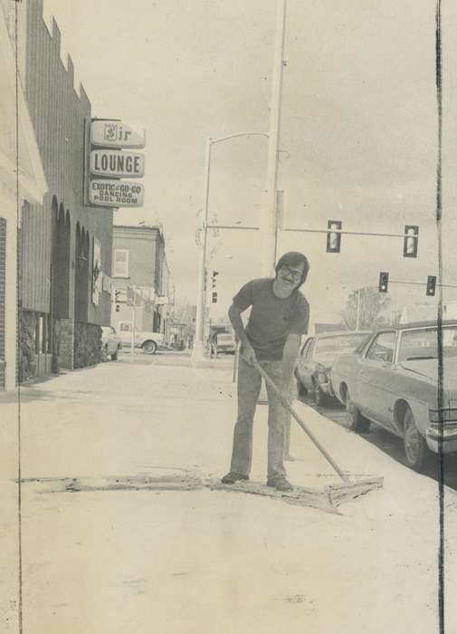 Cities and Towns, sidewalk, car, Businesses and Factories, Waverly Public Library, Portraits - Individual, man, Waverly, IA, shoveling, Winter, lounge, Iowa History, Iowa, history of Iowa, Main Streets & Town Squares, snow removal, Labor and Occupations