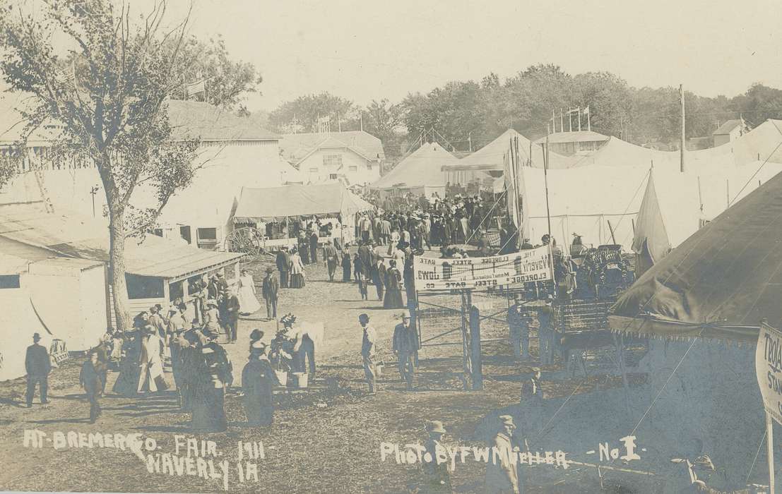 Fairs and Festivals, Entertainment, Iowa History, Families, homburg hat, long skirt, tents, Cities and Towns, Outdoor Recreation, cars, Iowa, history of Iowa, Motorized Vehicles, banner, bowler hat, Children, Waverly, IA, large decorated hat, county fair, Meyer, Sarah, Aerial Shots