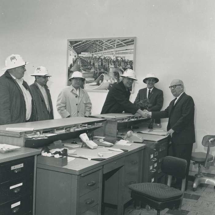 hard hat, photograph, telephone, calendar, Waverly Public Library, desk, man, glasses, history of Iowa, businessman, office chair, Iowa, Iowa History, Portraits - Group, Waverly, IA, file cabinet, correct date needed, suit