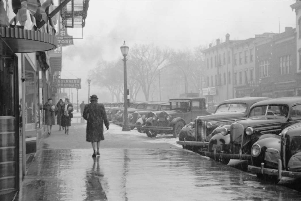 winter coat, storefront, main street, Cities and Towns, women, Iowa History, snow day, Motorized Vehicles, Main Streets & Town Squares, history of Iowa, automobile, street parking, Library of Congress, Iowa, Winter, Businesses and Factories