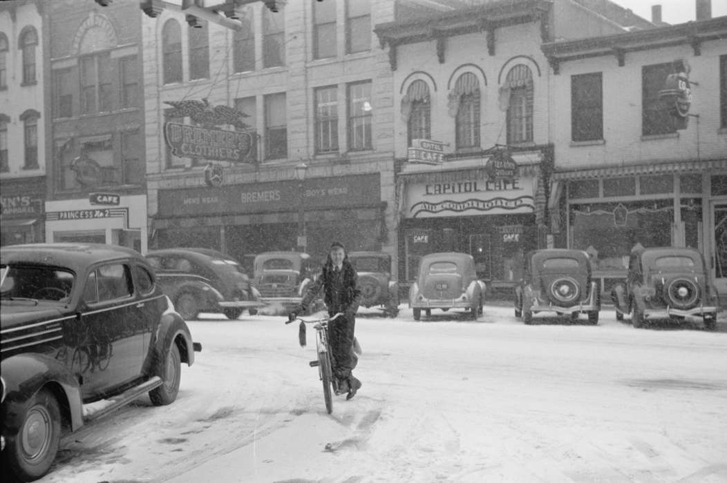 Entertainment, storefront, Cities and Towns, Children, Motorized Vehicles, Leisure, automobile, bicycle, buildings, Winter, Iowa, Businesses and Factories, Iowa History, snow day, Main Streets & Town Squares, Portraits - Individual, history of Iowa, street parking, Library of Congress, young boy, Outdoor Recreation