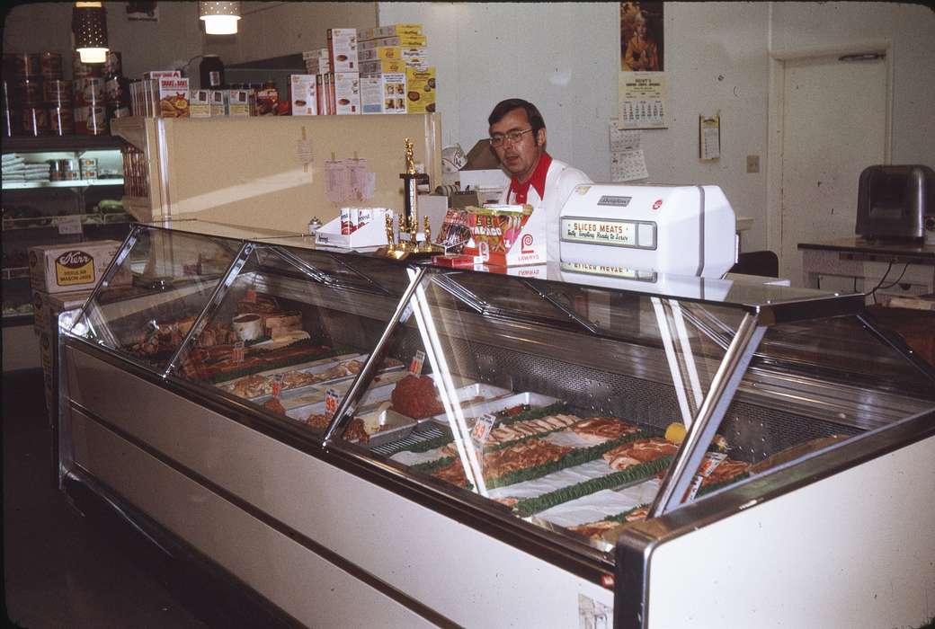 Businesses and Factories, Food and Meals, Adair, ground meat, history, store, deli meat, price, glasses, Labor and Occupations, Photos, prize, meat slicer, meat, Iowa, beef, IA, Cities and Towns, calendar, Greenfield, United States, steak, ia, can, grocery store, trophy, deli counter, groceries, man, supermarket, historic, business owner, Comstock, Sara