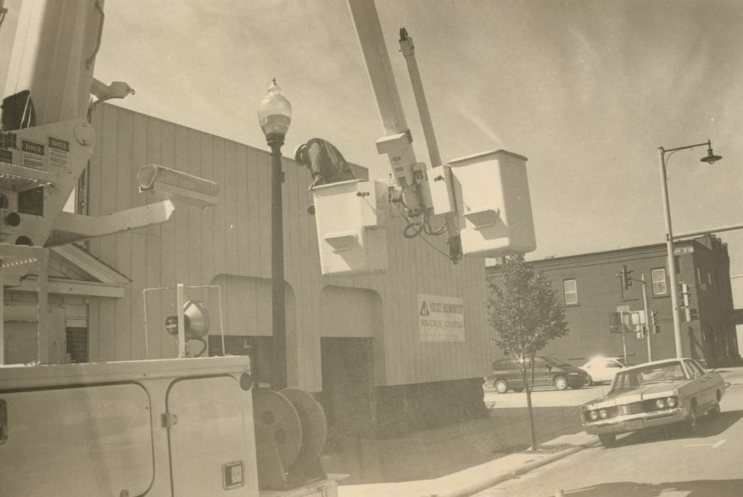 utility worker, Businesses and Factories, Motorized Vehicles, history of Iowa, sidewalk, utility truck, tree, electric company, car, Portraits - Individual, Waverly Public Library, Iowa, Iowa History, Labor and Occupations, lamppost, Cities and Towns, Main Streets & Town Squares
