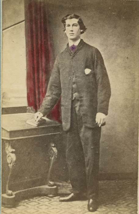 sack coat, desk, correct date needed, suit, Iowa History, colorized, vest, carte de visite, Olsson, Ann and Jons, Waterloo, IA, man, book, pocket square, curtain, Iowa, patterned carpet, history of Iowa, Portraits - Individual, bow tie