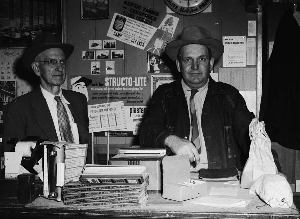 Businesses and Factories, history, Photos, glasses, Labor and Occupations, bulletin board, clock, Iowa, IA, calendar, two men, Portraits - Individual, United States, ia, Coon Rapids Enterprise, panama hat, necktie, historic, Coon Rapids