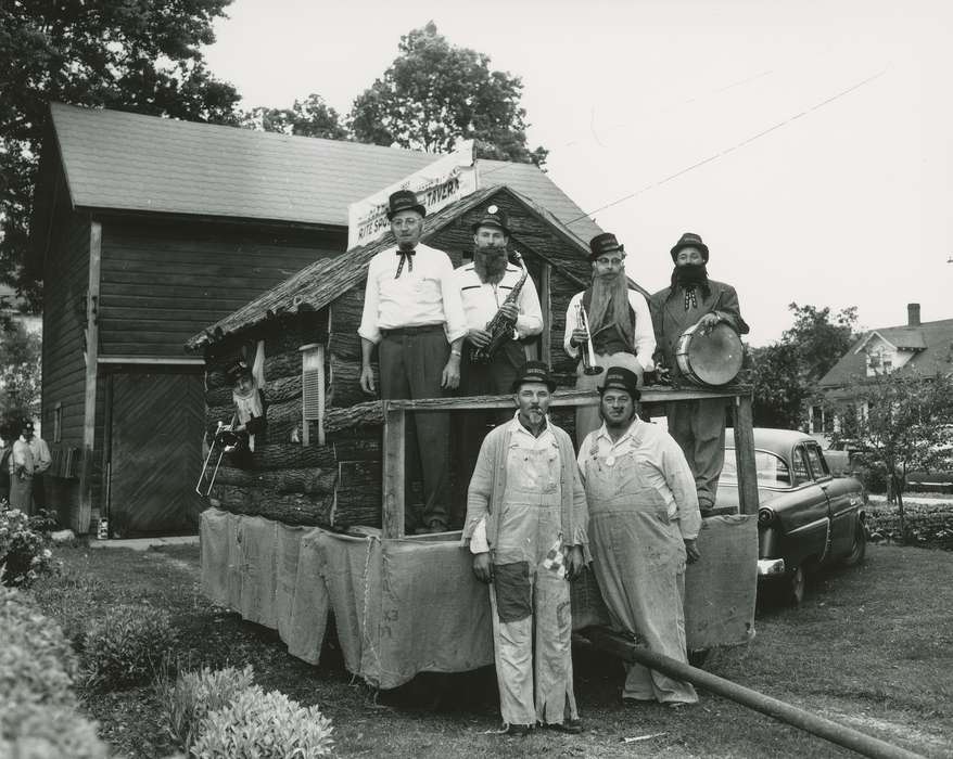 Waverly Public Library, parade float, Iowa History, Entertainment, trombone, saxophone, Portraits - Group, history of Iowa, bowler hat, Fairs and Festivals, cigar, glasses, beard, trumpet, drum, moustache, overalls, log cabin, washboard, bow tie, Iowa